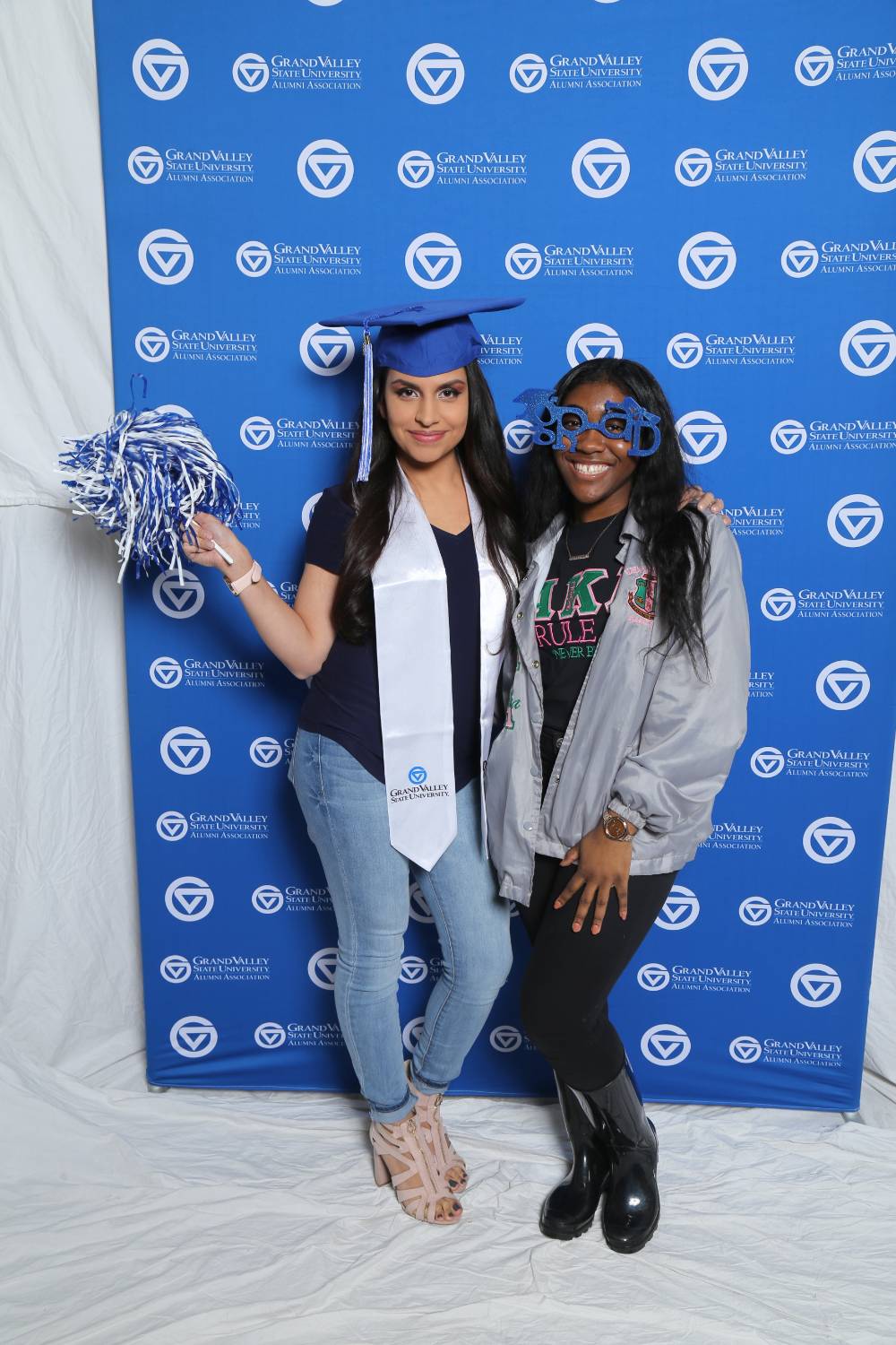 Two friends pose with props at Gradfest